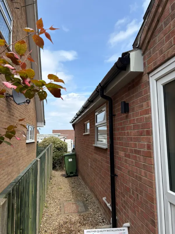 Stone Grey uPVC windows with new black guttering and downpipe on an Ipswich bungalow